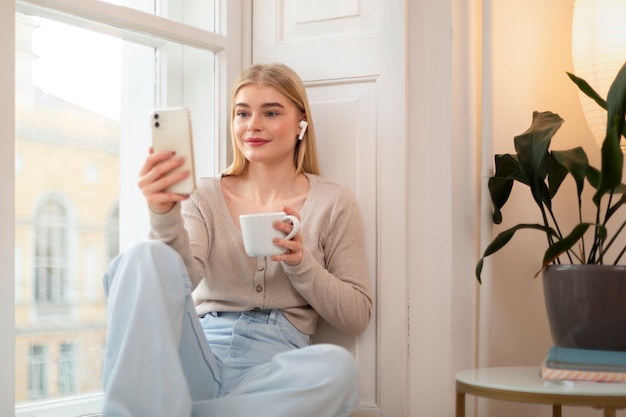 Foto gratuita mujer de tiro medio con teléfono inteligente