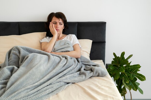 Mujer de tiro medio tendido en la cama