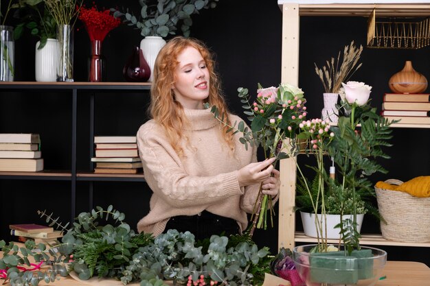 Mujer de tiro medio en la tienda de flores