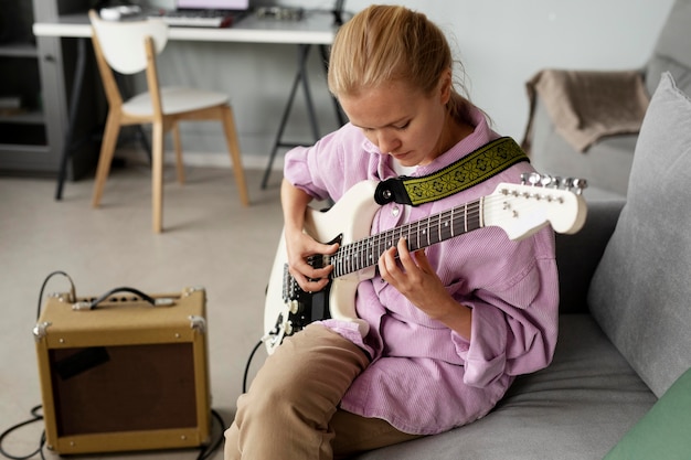 Mujer de tiro medio tocando la guitarra