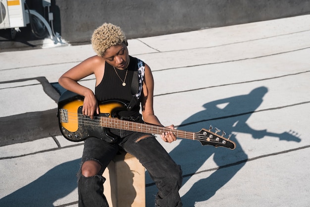 Foto gratuita mujer de tiro medio tocando la guitarra