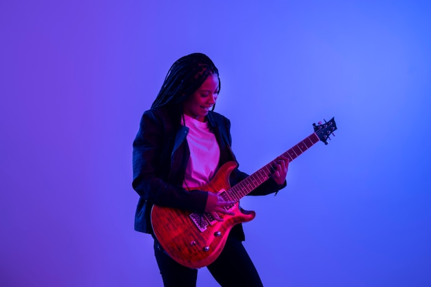 Mujer de tiro medio tocando la guitarra