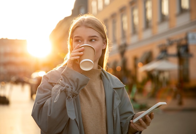 Mujer de tiro medio tomando café