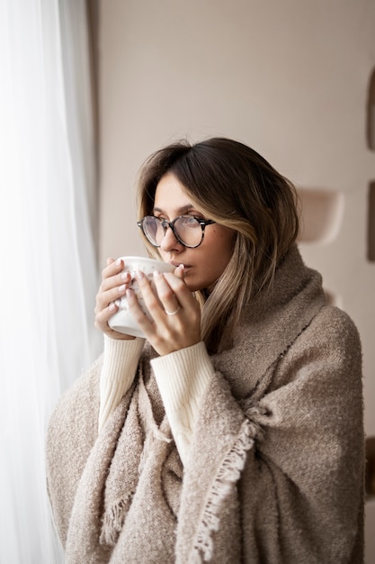 Mujer de tiro medio tomando café