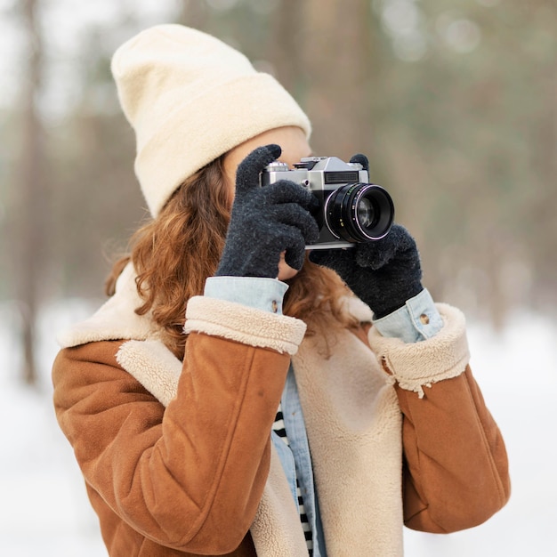 Foto gratuita mujer de tiro medio tomando fotos en el bosque