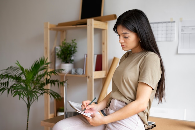 Mujer de tiro medio tomando notas