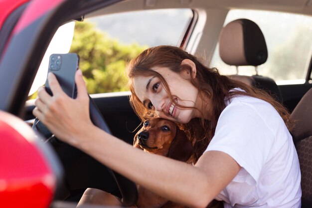 Mujer de tiro medio tomando selfie con perro