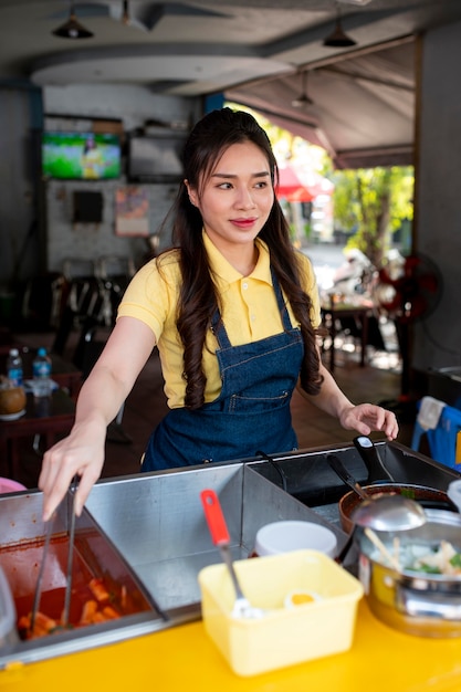 Mujer de tiro medio trabajando en camión de comida