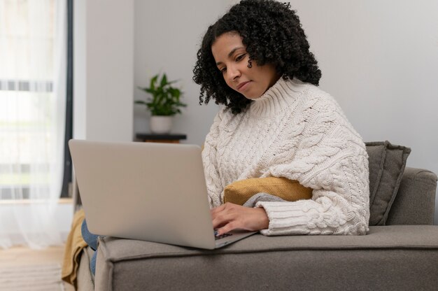 Mujer de tiro medio trabajando en la computadora portátil