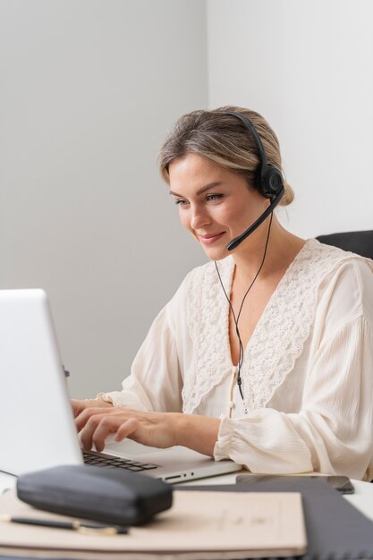 Mujer de tiro medio trabajando en la computadora portátil