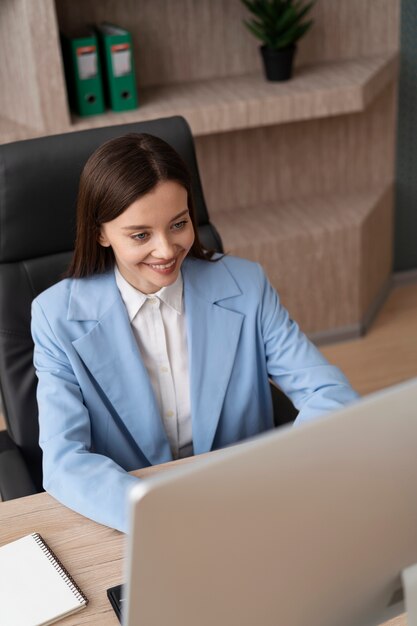 Mujer de tiro medio trabajando en la computadora