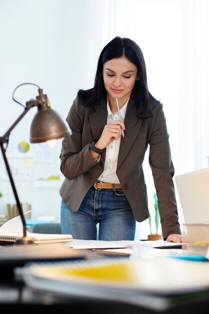 Mujer de tiro medio trabajando en el escritorio