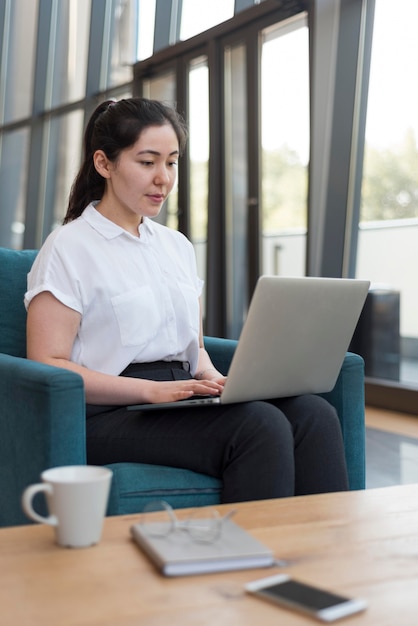 Mujer de tiro medio trabajando en interiores