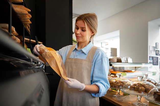 Foto gratuita mujer de tiro medio trabajando en panadería