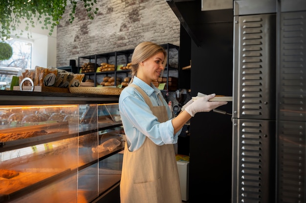 Foto gratuita mujer de tiro medio trabajando en panadería