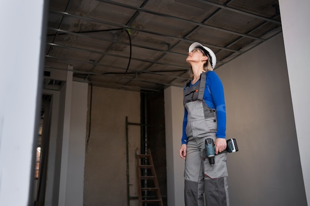 Mujer de tiro medio trabajando con taladro