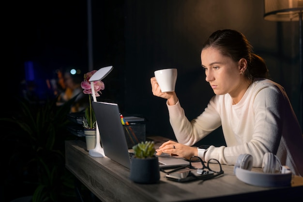 Foto gratuita mujer de tiro medio trabajando tarde en la noche