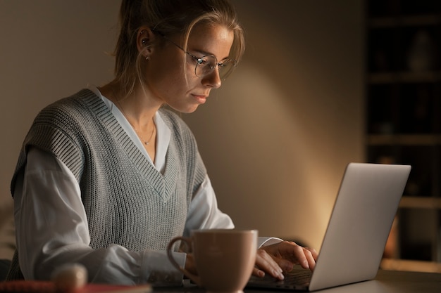 Foto gratuita mujer de tiro medio trabajando tarde en la noche