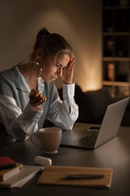 Mujer de tiro medio trabajando tarde en la noche