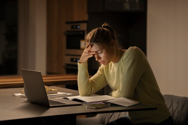 Mujer de tiro medio trabajando tarde en la noche