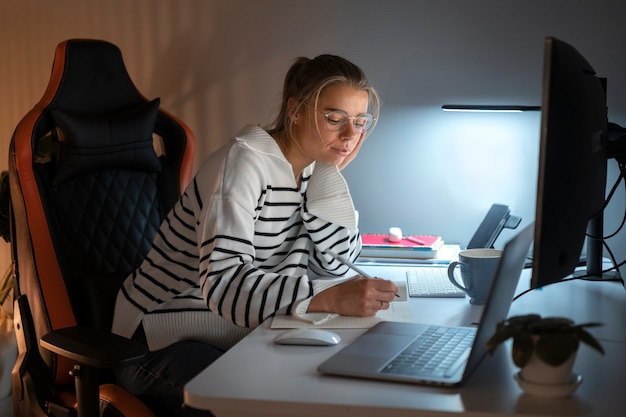 Mujer de tiro medio trabajando tarde en la noche