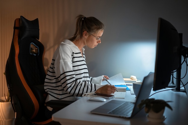 Mujer de tiro medio trabajando tarde en la noche