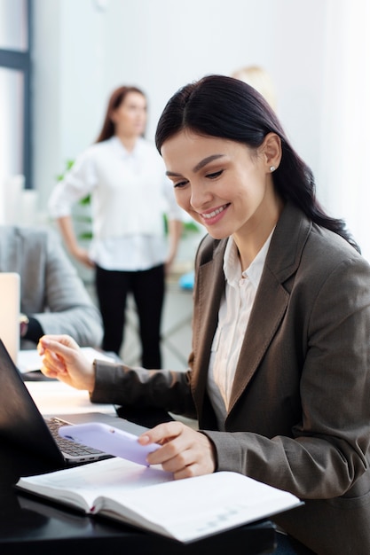 Foto gratuita mujer de tiro medio trabajando con teléfono