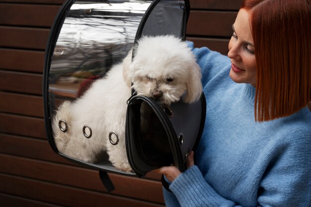 Mujer de tiro medio con transportador de mascotas.