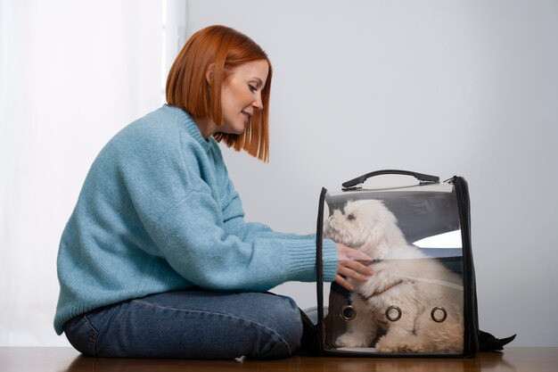 Mujer de tiro medio con transportador de mascotas.