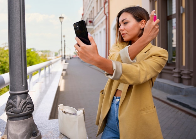 Foto gratuita mujer de tiro medio usando champú seco al aire libre