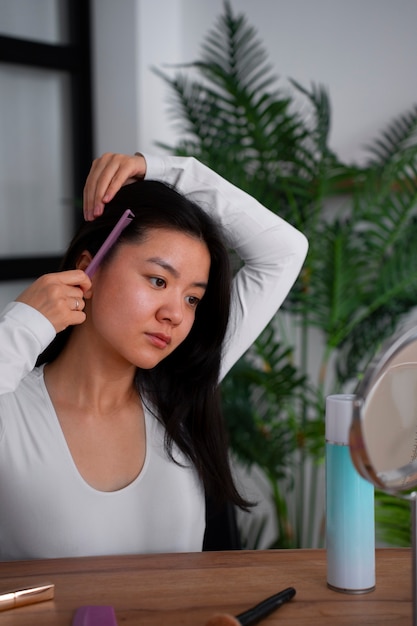 Foto gratuita mujer de tiro medio usando champú seco en casa