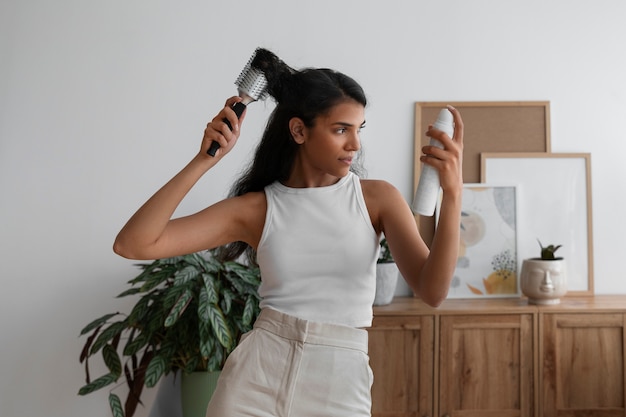 Foto gratuita mujer de tiro medio usando champú seco en casa