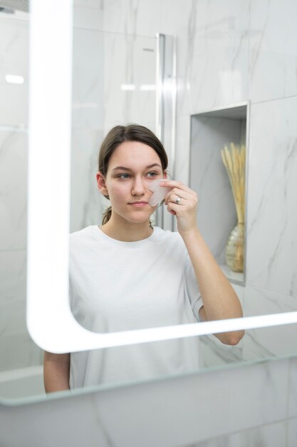 Mujer de tiro medio usando gua sha