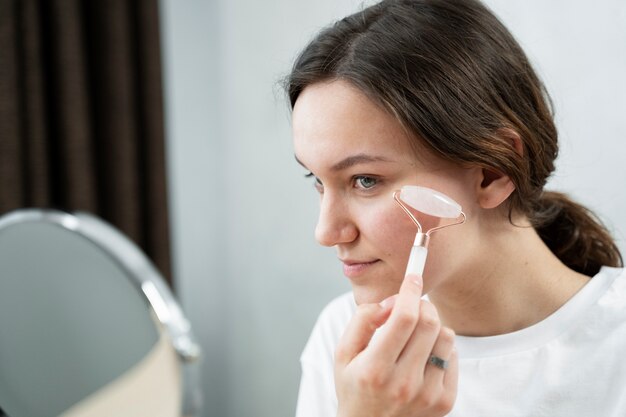 Mujer de tiro medio usando la herramienta facial