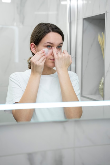 Mujer de tiro medio usando la herramienta gua sha