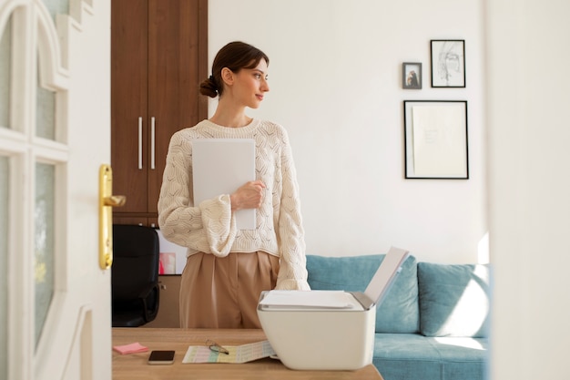 Mujer de tiro medio usando impresora en el trabajo