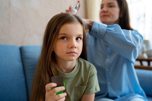 Mujer de tiro medio usando solución para piojos