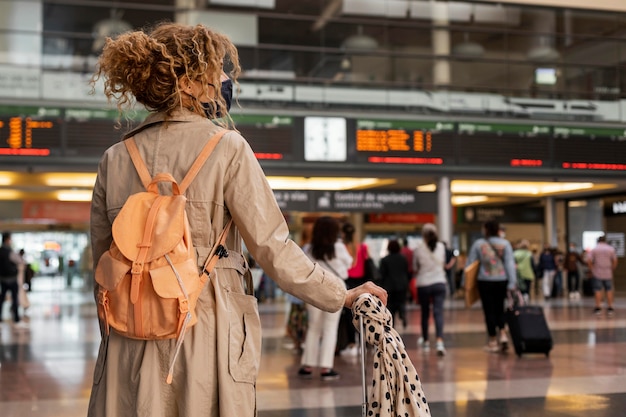 Mujer de tiro medio viajando con máscara