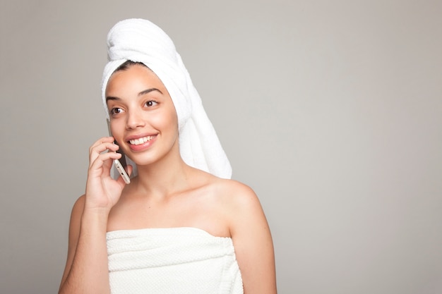 Mujer en toalla haciendo una llamada telefónica