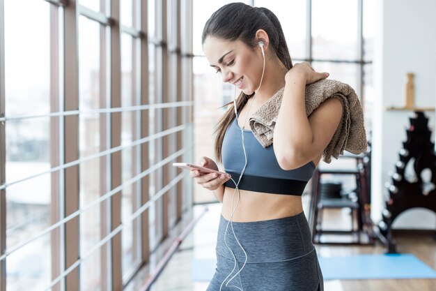 Mujer con toalla y teléfono inteligente