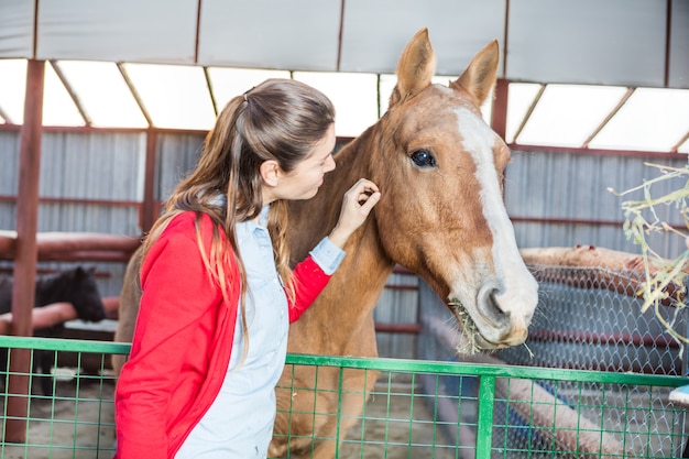 Foto gratuita mujer tocando al caballo mientras come