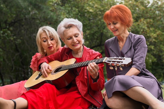 Foto gratuita mujer tocando la guitarra para amigos