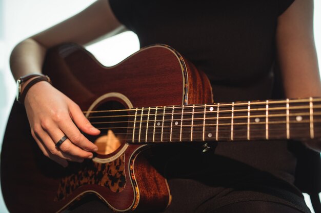 Mujer tocando una guitarra en la escuela de música