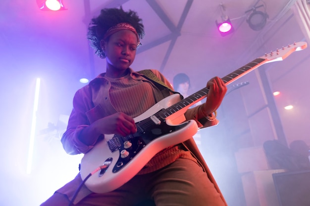 Mujer tocando la guitarra en un evento local.