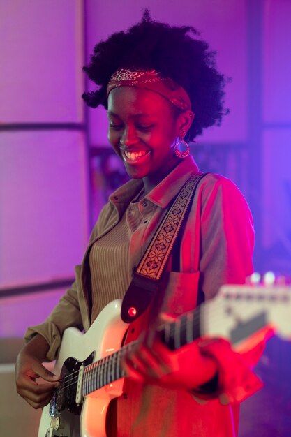 Mujer tocando la guitarra en un evento local.