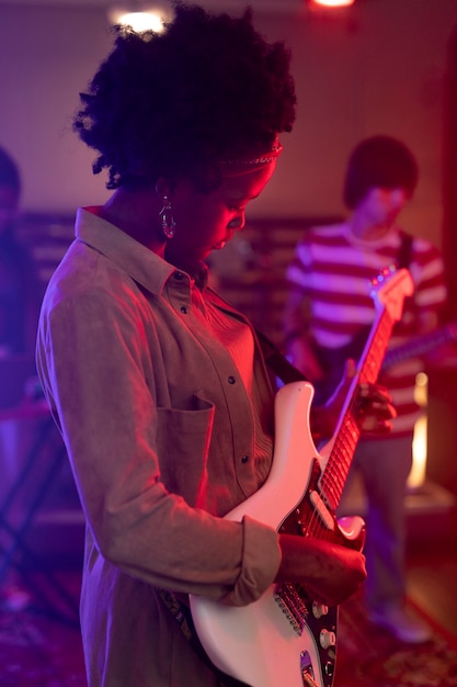 Mujer tocando la guitarra en un evento local.