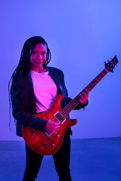 Mujer tocando la guitarra tiro medio