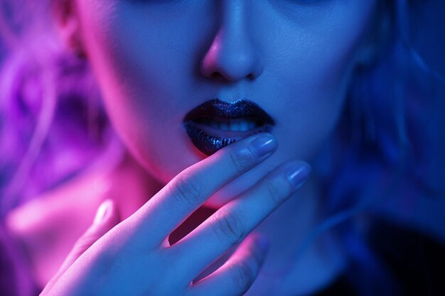 Mujer tocando labios brillantes