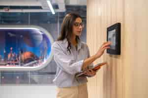 Foto gratuita mujer tocando el panel de control en la pared del corredor