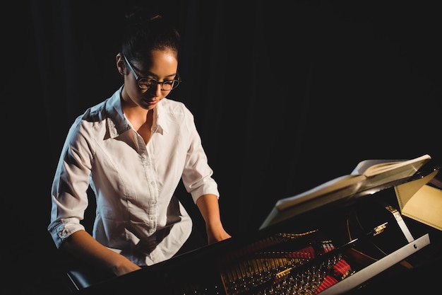 Foto gratuita mujer tocando el piano en el estudio de música